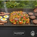 Blackstone recipes: Blackstone outdoor griddle with bacon, eggs, colorful vegetables, and hamburger patties being grilled.